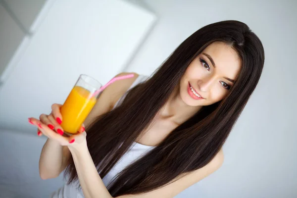 Mujer bebiendo jugo de naranja en el dormitorio —  Fotos de Stock