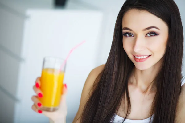 Ung kvinna njuter av ett glas apelsinjuice på morgonen som s — Stockfoto