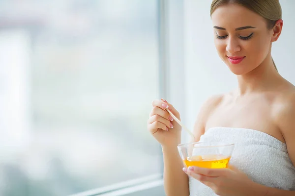 Vrouwen houden oranje paraffine kom. Vrouw in de beauty salon — Stockfoto