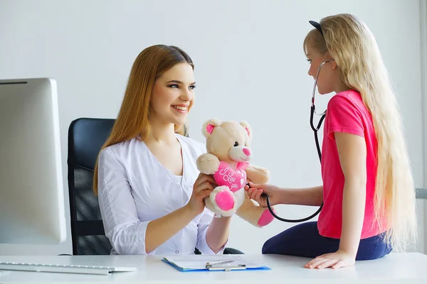 Knappe dokter onderzoeken meisje met stethoscoop — Stockfoto