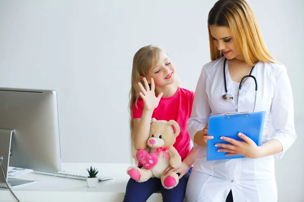 Guapo doctor examinando pequeña niña con estetoscopio —  Fotos de Stock