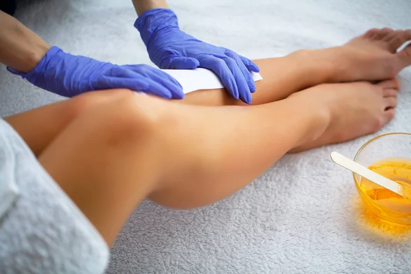 Waxing. Beautician Waxing Woman\'s Leg In Spa Salon
