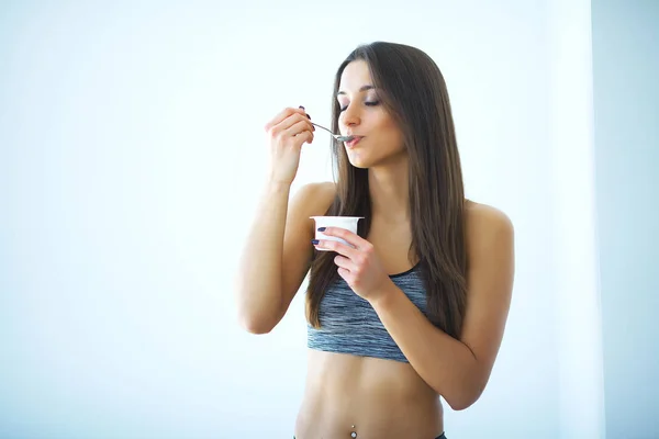 Diety. Szczęśliwa młoda kobieta jedzenie jogurt w kuchni — Zdjęcie stockowe