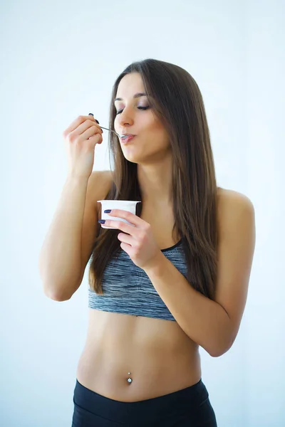 Портрет улыбающейся женщины, поедающей йогурт — стоковое фото