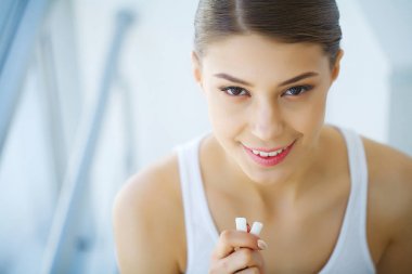 Güzel genç bir kadın sakız yiyor, gülümsüyor.