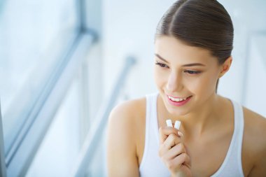 Güzel genç bir kadın sakız yiyor, gülümsüyor.