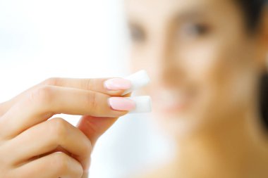 Güzel genç bir kadın sakız yiyor, gülümsüyor.