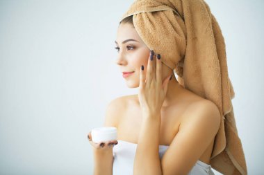 Bir cilt bakım ürünü, nemlendirici veya loti kullanarak güzel bir kadın