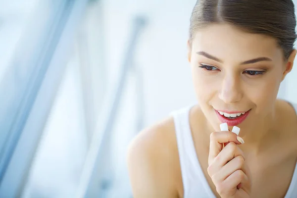 Bella giovane donna mangiare gomma da masticare, sorridente — Foto Stock
