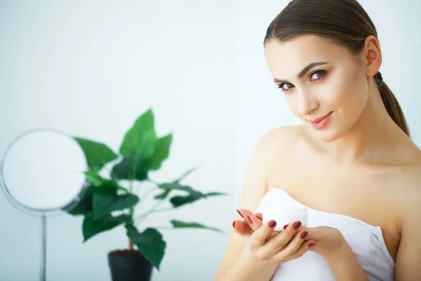 Eine schöne Frau mit einem Hautpflegeprodukt, Feuchtigkeitscreme oder Loti — Stockfoto