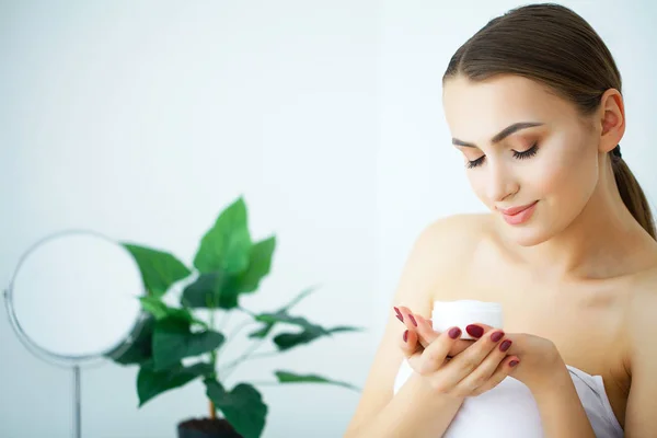 Cuidado de la piel de belleza. Hermosa mujer aplicando crema facial cosmética —  Fotos de Stock