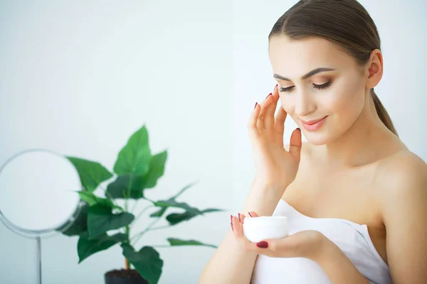 Cuidados com a pele beleza. Mulher bonita aplicando creme facial cosmético — Fotografia de Stock