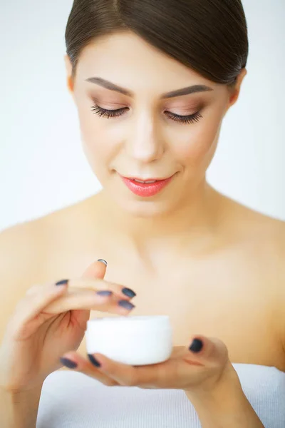Een mooie vrouw met behulp van een product van de huidzorg, -vochtinbrengende crème of loti — Stockfoto