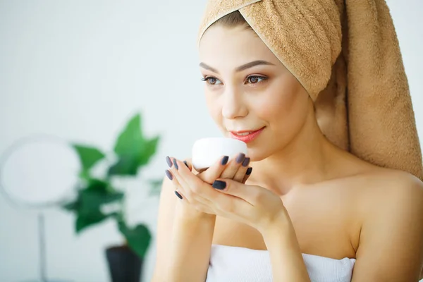 Gezicht schoonheidsverzorging. Vrouw toepassen crème op de huid. — Stockfoto