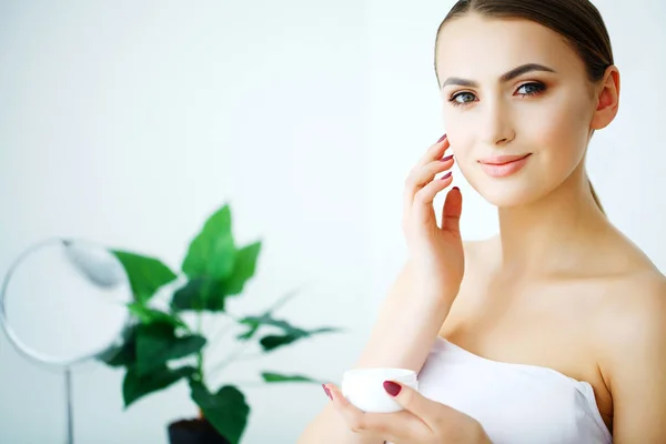 Gezicht schoonheidsverzorging. Vrouw toepassen crème op de huid. — Stockfoto
