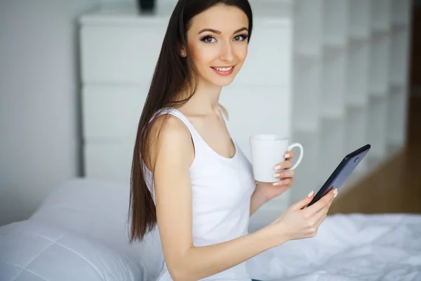 Jong mooi vrouw zitten op bed — Stockfoto