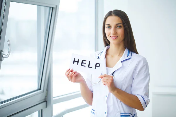 Female hands holding paper with inscription Help — Stock Photo, Image