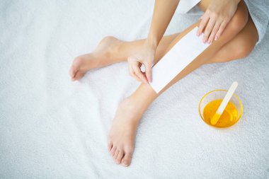 Sugaring: epilation with liquate sugar at legs. clipart