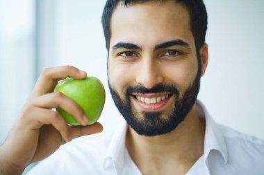 Elma olan adam. Güzel erkek ile beyaz gülümseme, sağlıklı dişler. 