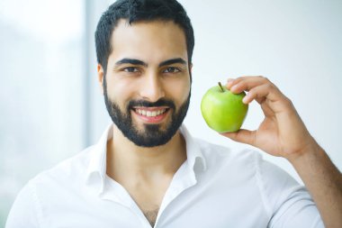 Elma olan adam. Güzel erkek ile beyaz gülümseme, sağlıklı dişler. 
