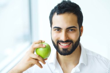Elma olan adam. Güzel erkek ile beyaz gülümseme, sağlıklı dişler. 