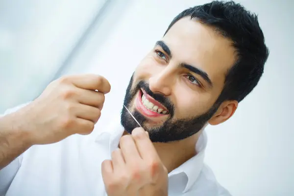 치아 관리입니다. 건강 한 치아를 Flossing 아름 다운 웃는 남자. — 스톡 사진