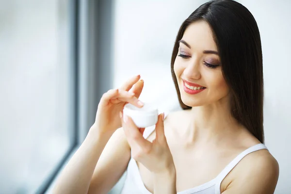 Cuidados com a beleza. Mulher aplicando creme na pele . — Fotografia de Stock