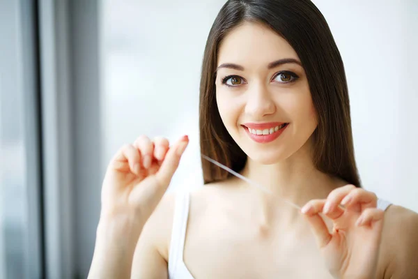 Cuidado com os dentes. Mulher sorridente bonita Flossing dentes brancos saudáveis — Fotografia de Stock