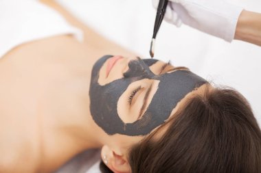 yüz maskesi Güzellik Salonu sahip genç bir kadın için spa terapisi -