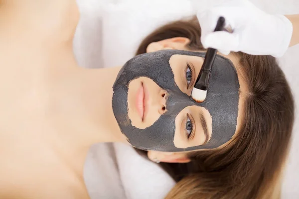 Mujer con máscara en la cara en el salón de belleza del spa. — Foto de Stock