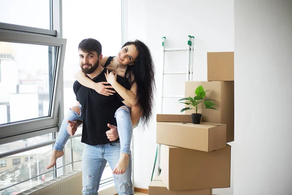 Pareja mostrando las llaves de un nuevo hogar abrazando mirando a la cámara — Foto de Stock