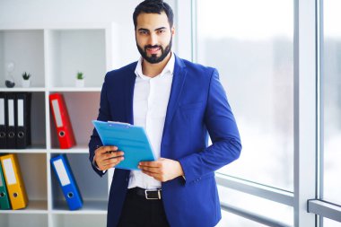 Ofiste bilgisayar üzerinde çalışan genç işadamı