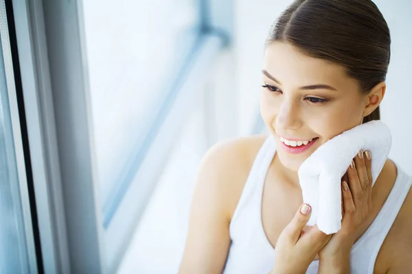 Молода жінка сушить себе білим рушником, посміхаючись, портрет , — стокове фото