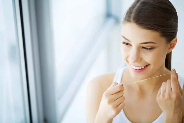 Cuidado com os dentes. Mulher sorridente bonita Flossing dentes brancos saudáveis — Fotografia de Stock