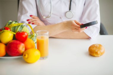 Elma, kivi, limon ve beslenme uzmanı masada çilek gibi bazı meyveler