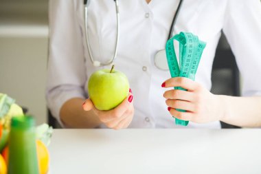 Diyet. Kadın beslenme uzmanı ve bir elma ve bir ölçü birimi musluk Holding