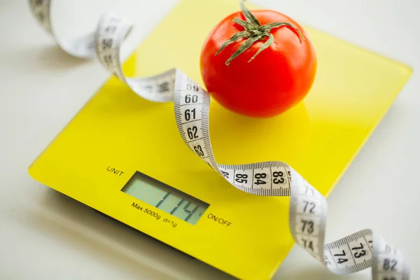 Dieta. Tomate com fita métrica em balança de peso — Fotografia de Stock