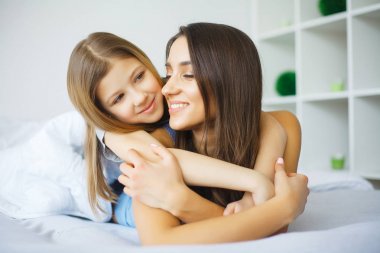 Anne ve kızı yatakta yatarken