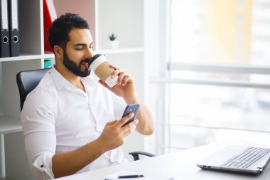 Neşeli genç yakışıklı modern yönetmen h bir dizüstü bilgisayar üzerinde çalışan