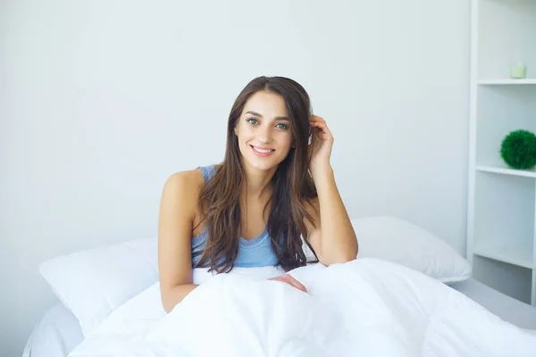 Junge Schönheit schläft in einem weißen Bett — Stockfoto