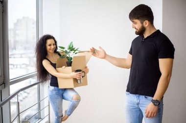 Gülümseyen iki yeni ev kutuları açmak.