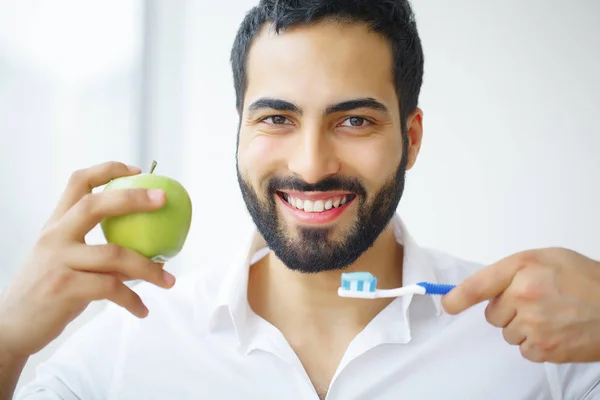 Man Eating Apple. Beautiful Girl With White Teeth Biting Apple.