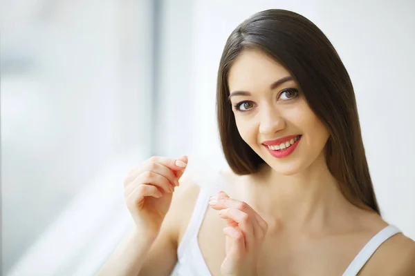 Branqueamento dos dentes. Mulher sorridente bonita segurando Whitening Strip — Fotografia de Stock