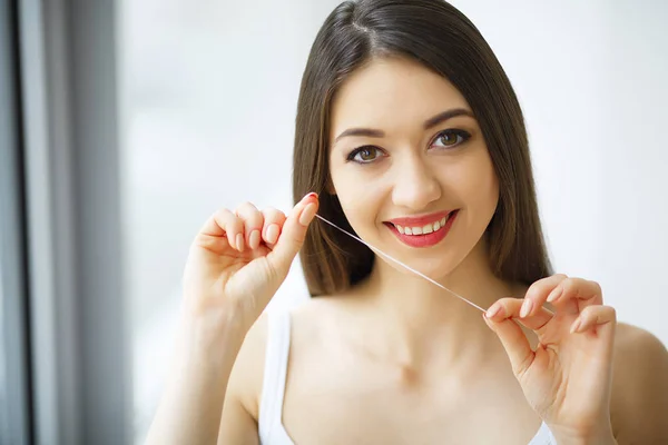 Saúde dentária. Mulher com belo sorriso Flossing dentes saudáveis — Fotografia de Stock