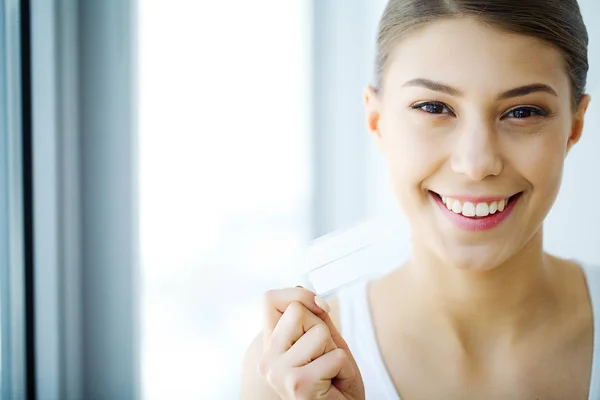 Branqueamento dos dentes. Mulher sorridente bonita segurando Whitening Strip — Fotografia de Stock