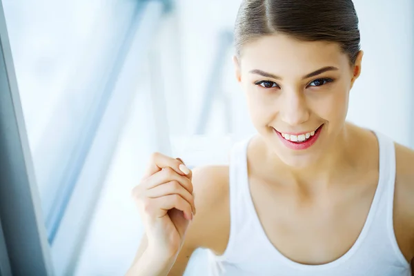 Tandblekning. Vackra leende kvinna som håller tandblekning Strip — Stockfoto
