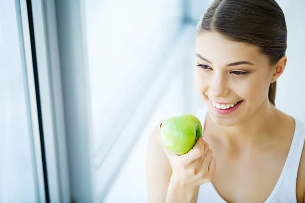 Donna sorridente con bel sorriso, denti bianchi che tengono mela. H — Foto Stock