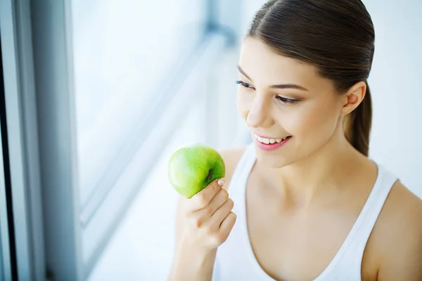 Donna sorridente con bel sorriso, denti bianchi che tengono mela. H — Foto Stock