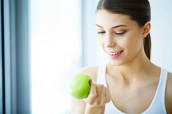 Mujer sonriente con hermosa sonrisa, dientes blancos sosteniendo manzana. H —  Fotos de Stock