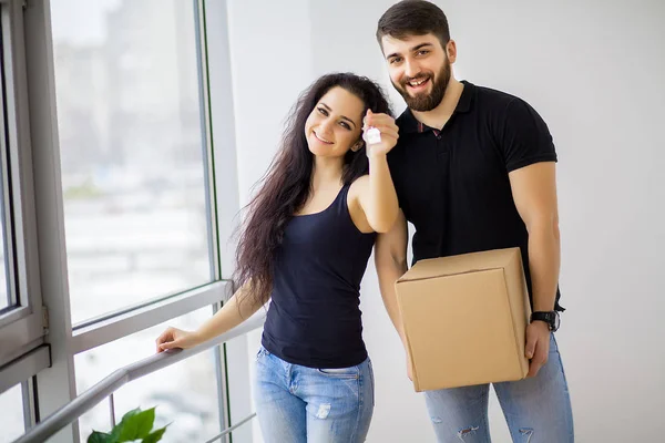 Glada unga par som flyttar i nya hem packa upp lådor — Stockfoto